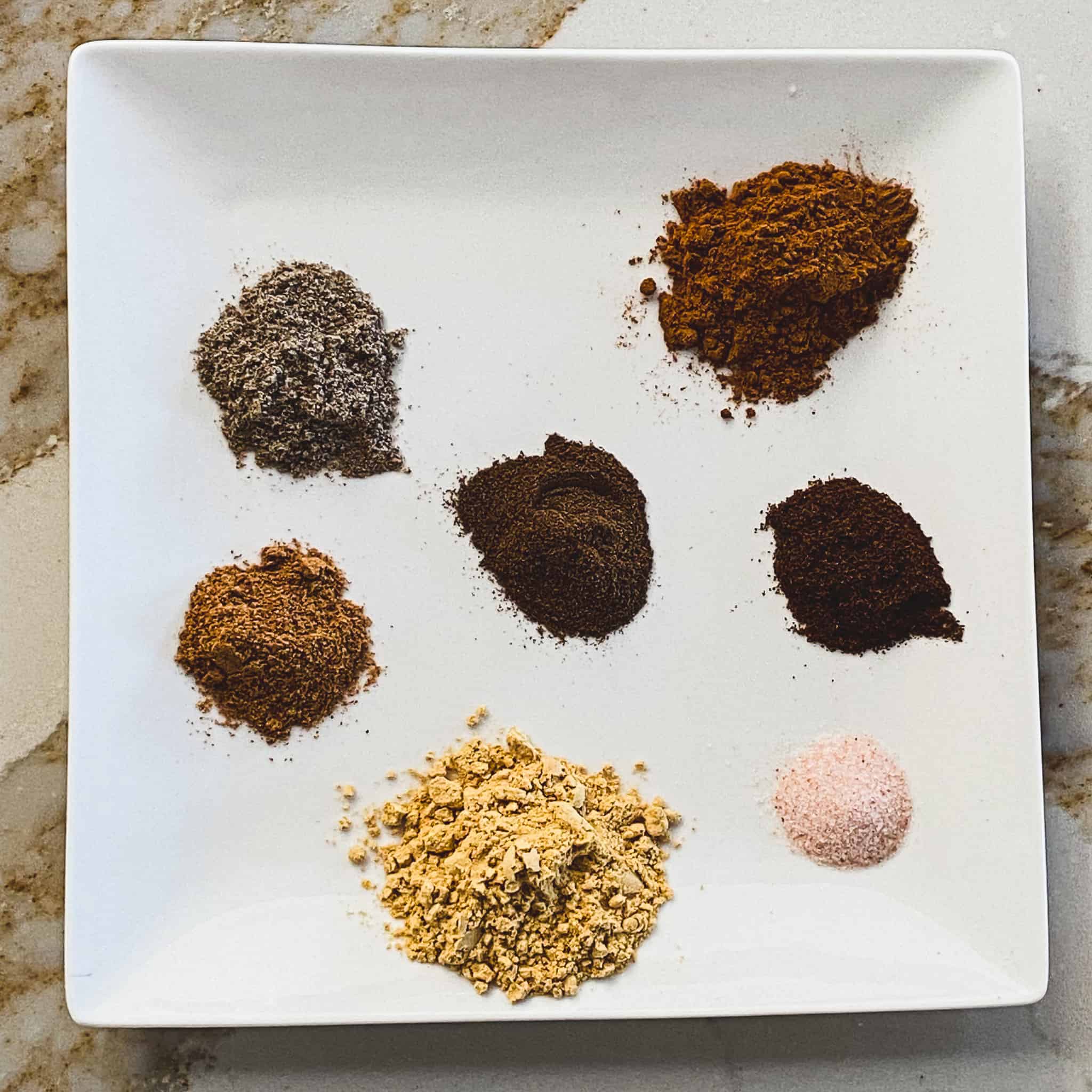 Chai spices displayed on a plate.