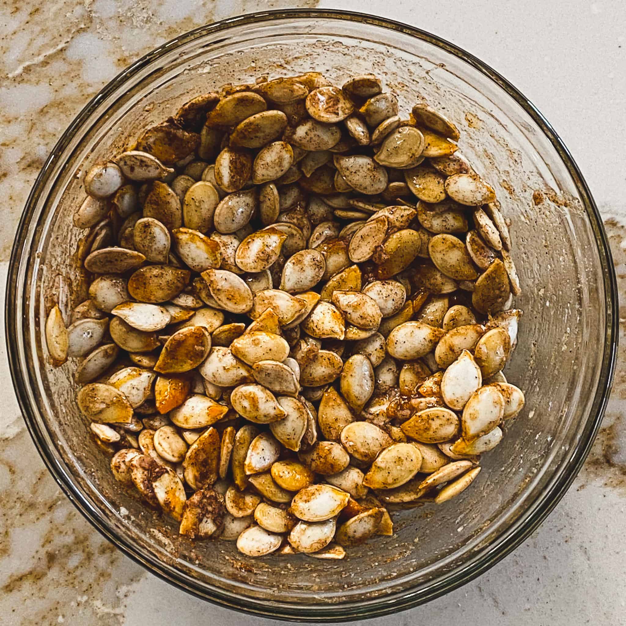 Sweet and Salty Chai spiced pumpkin seeds mixed in a glass bowl.