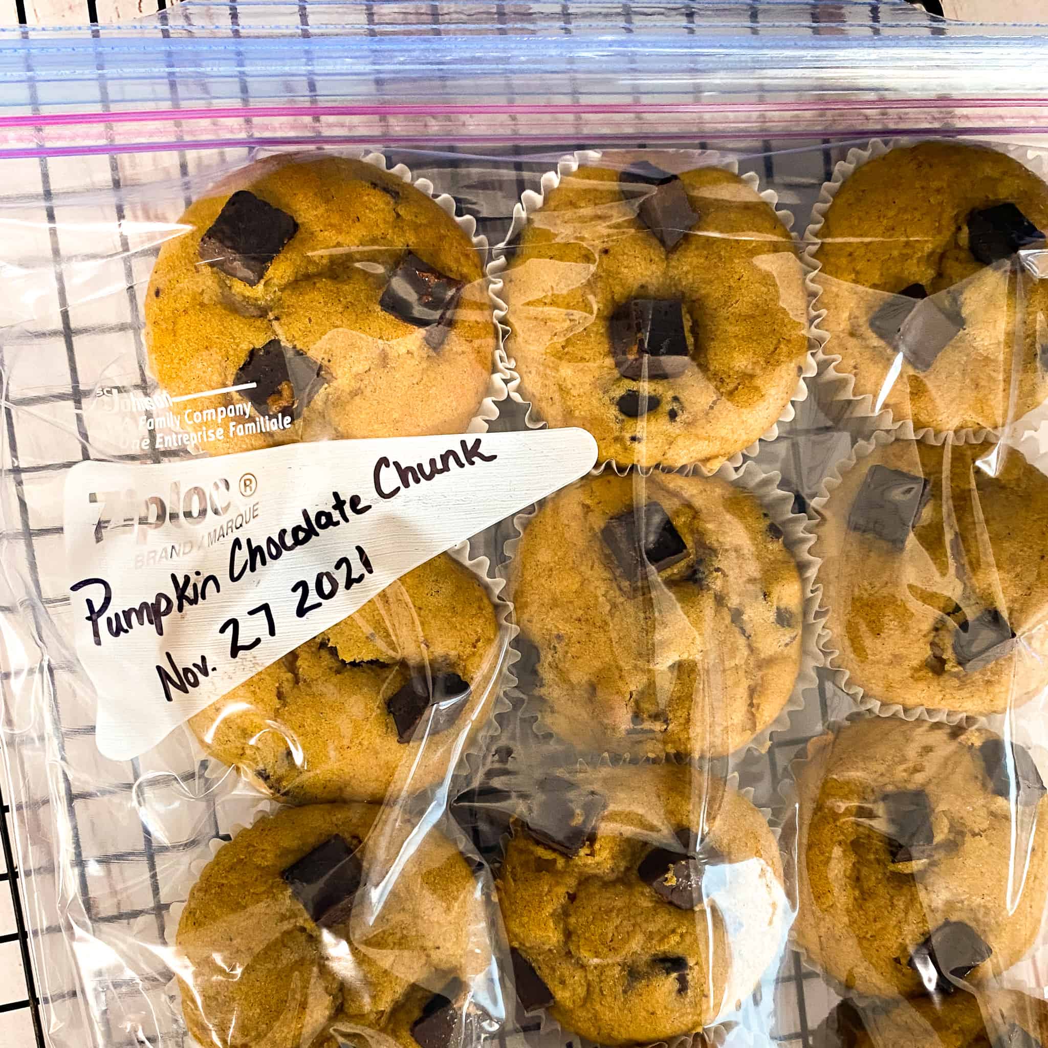 A large ziplock bag filled with pumpkin chocolate chunk muffins. The bag has little air in it and is ready for the freezer.