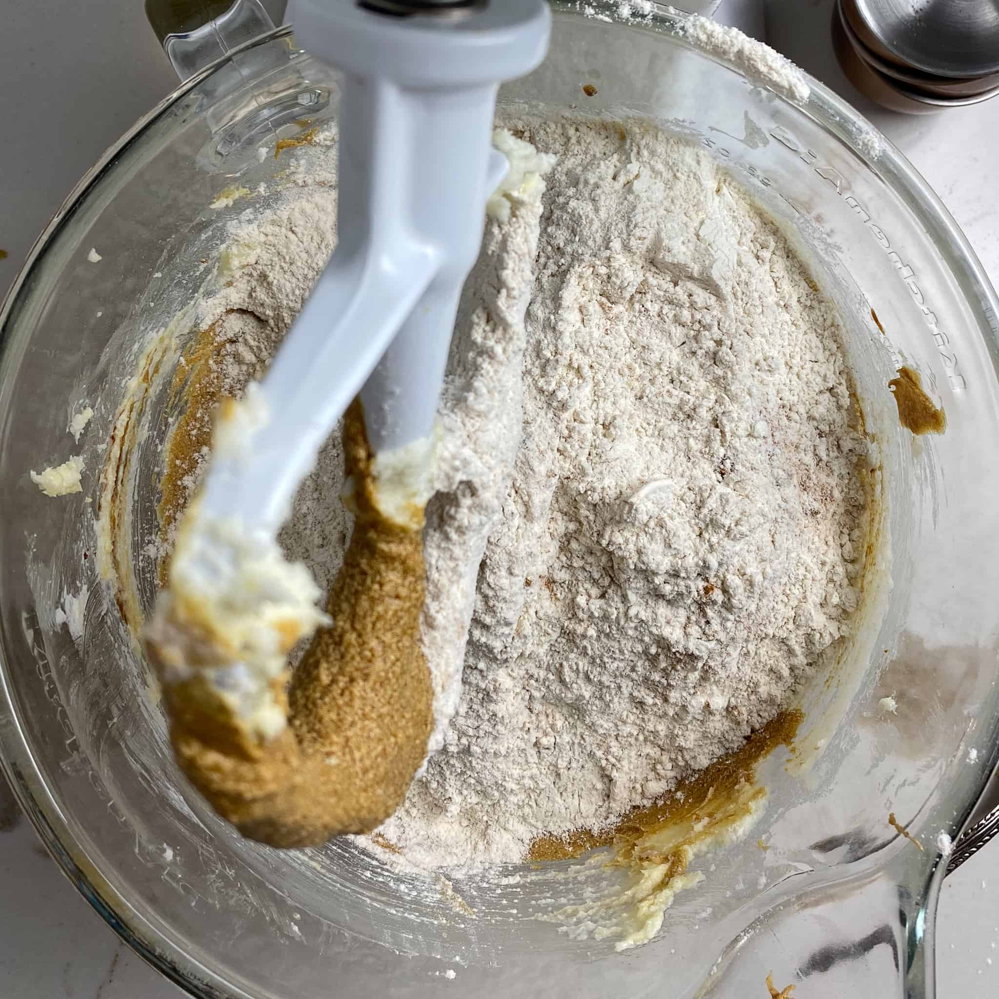 Flour being added to the wet ingredients for old fashioned ginger snap cookies.