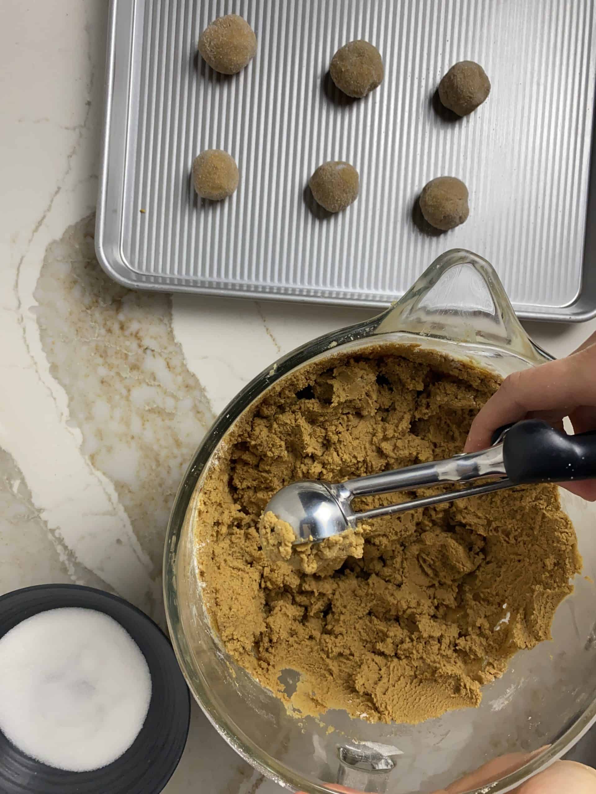 Scooping out the ginger snap cookie dough onto a cookie sheet.