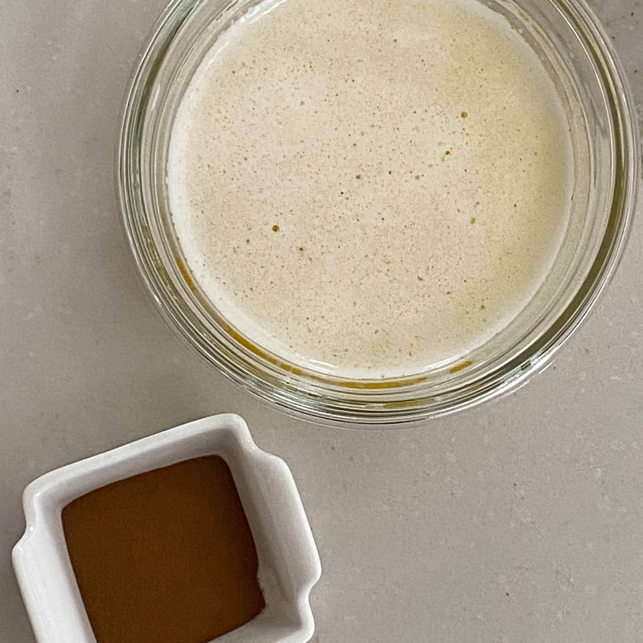 Espresso powder in a small white square dish and melted butter in a glass bowl.