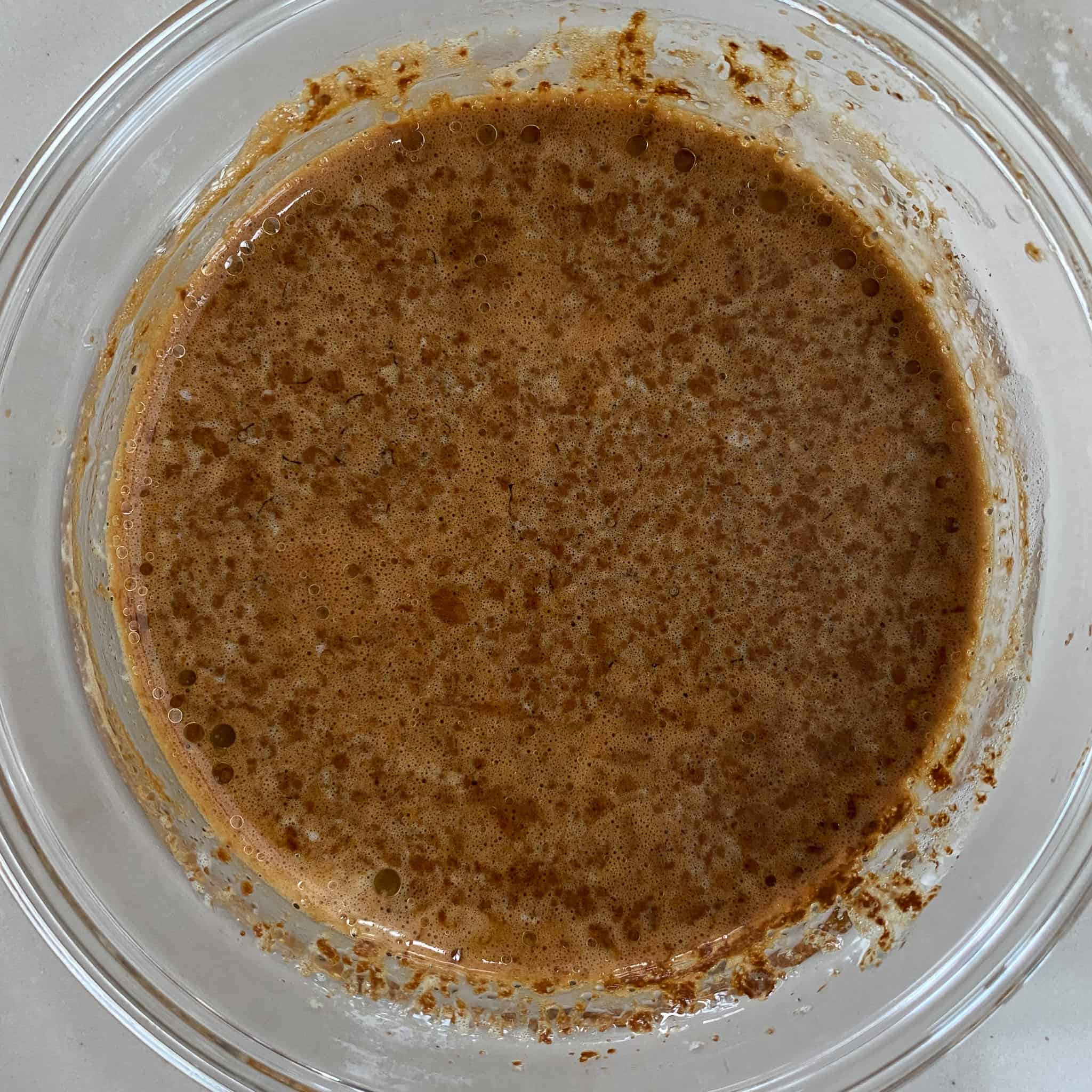 Butter and espresso powder mixed in a glass bowl.