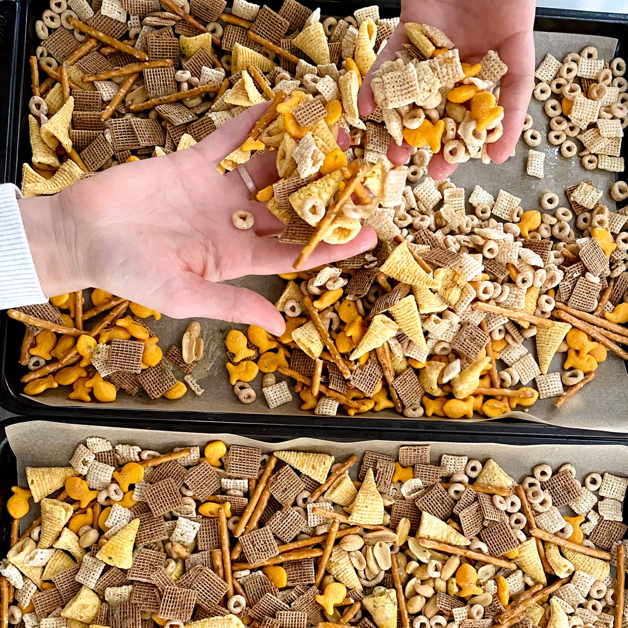 Mixing the Chex mix by hand.