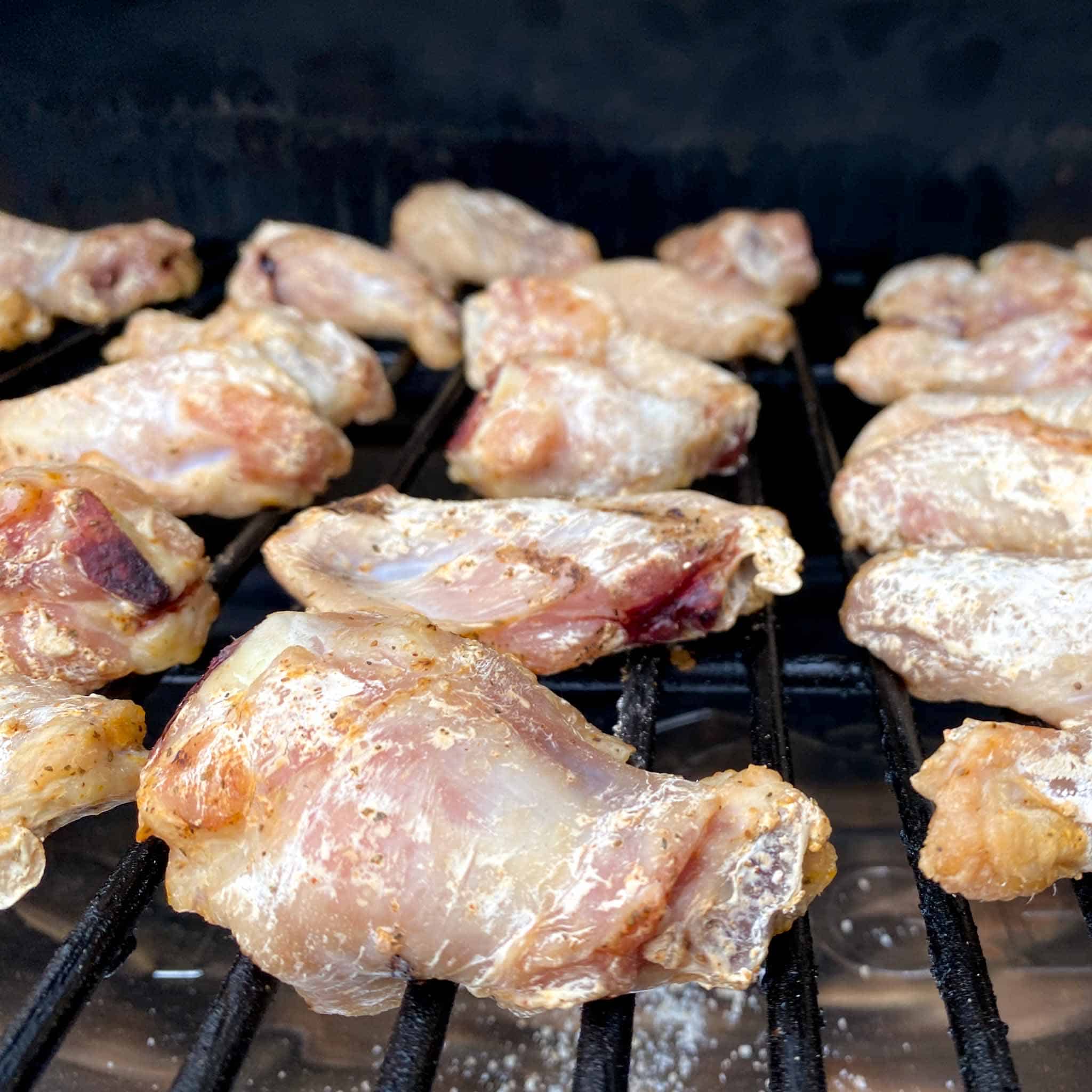 Partially cooked wings on a traeger pellet grill.