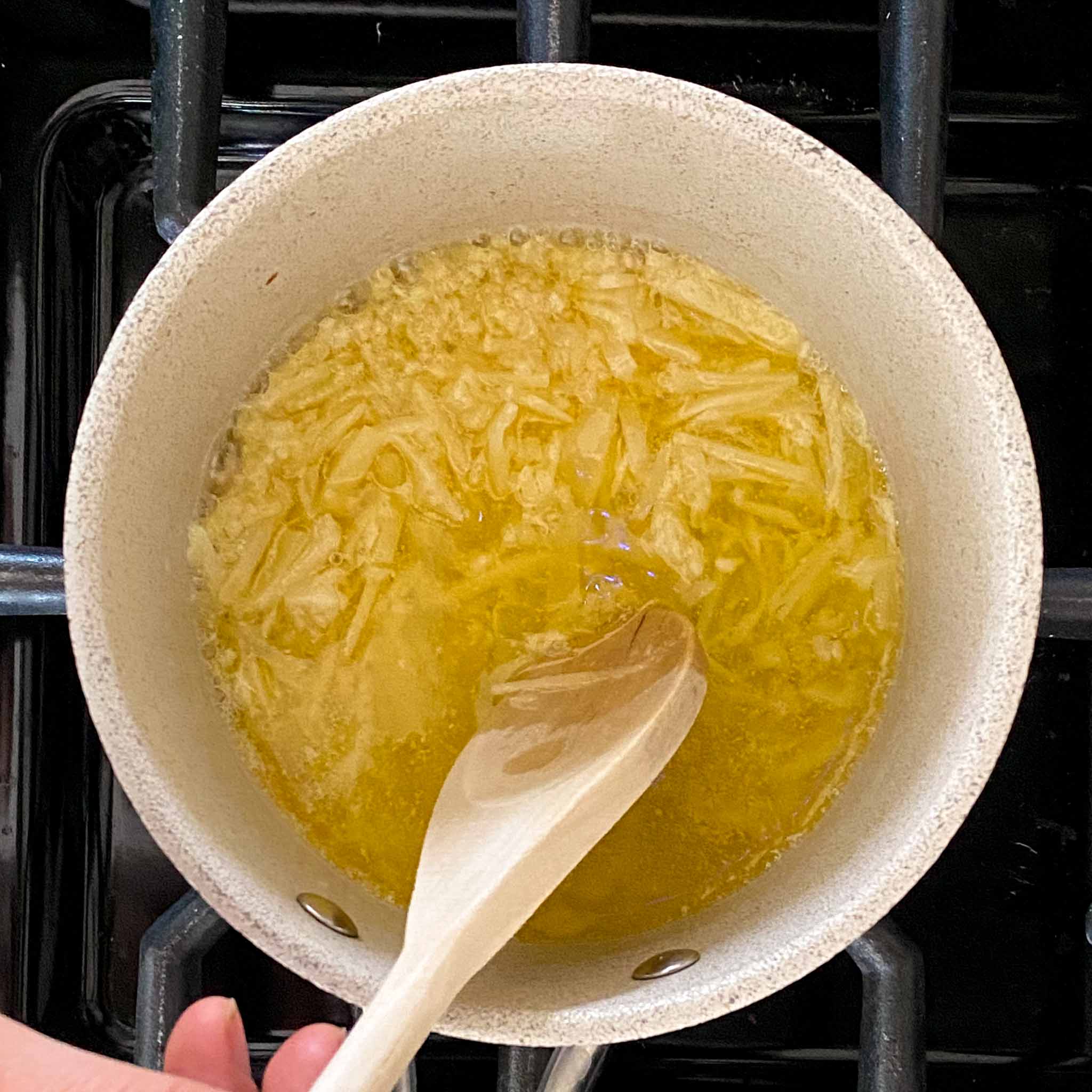 Parmesan being mixed into butter to make a wing sauce.