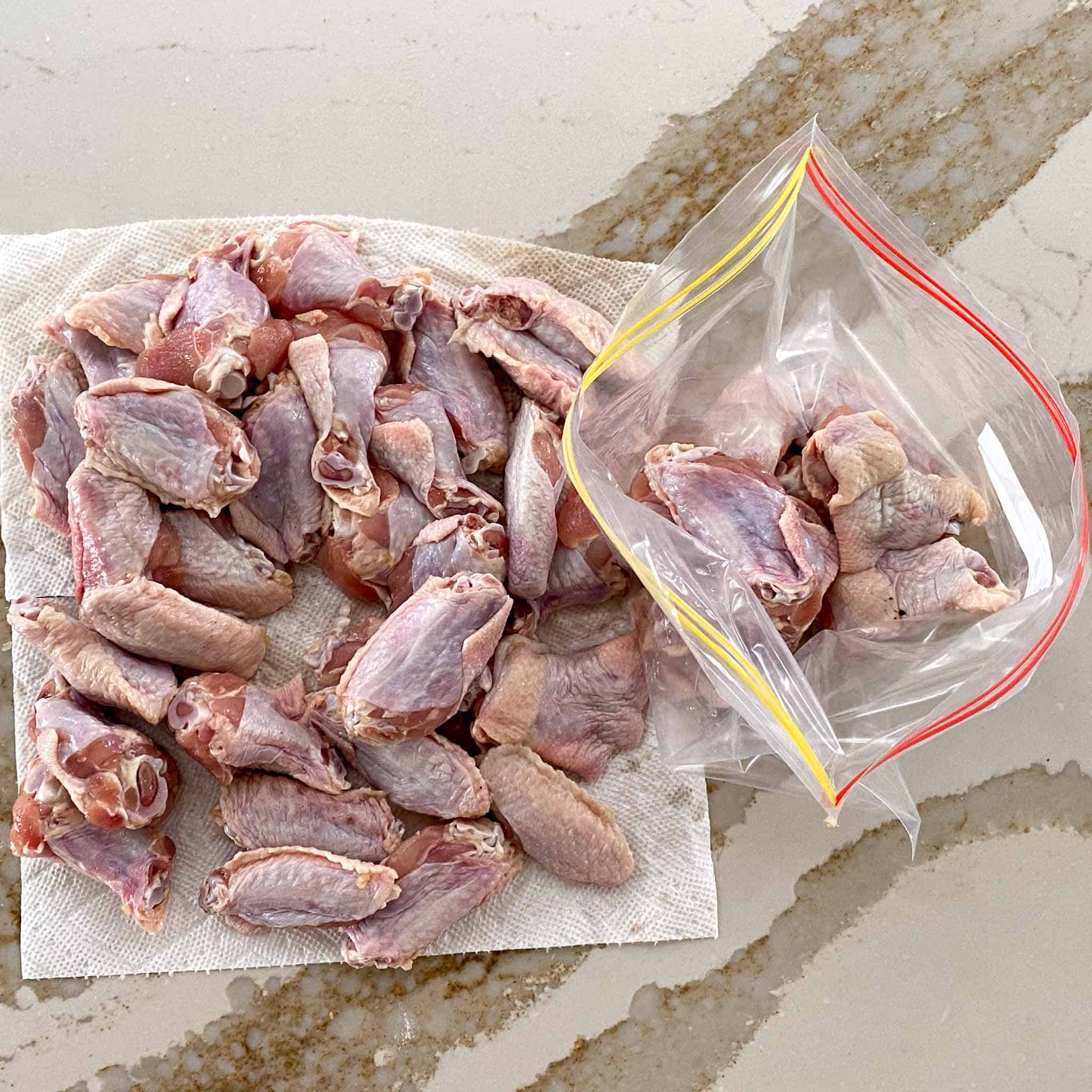 Raw chicken wings on a paper towel to dry.