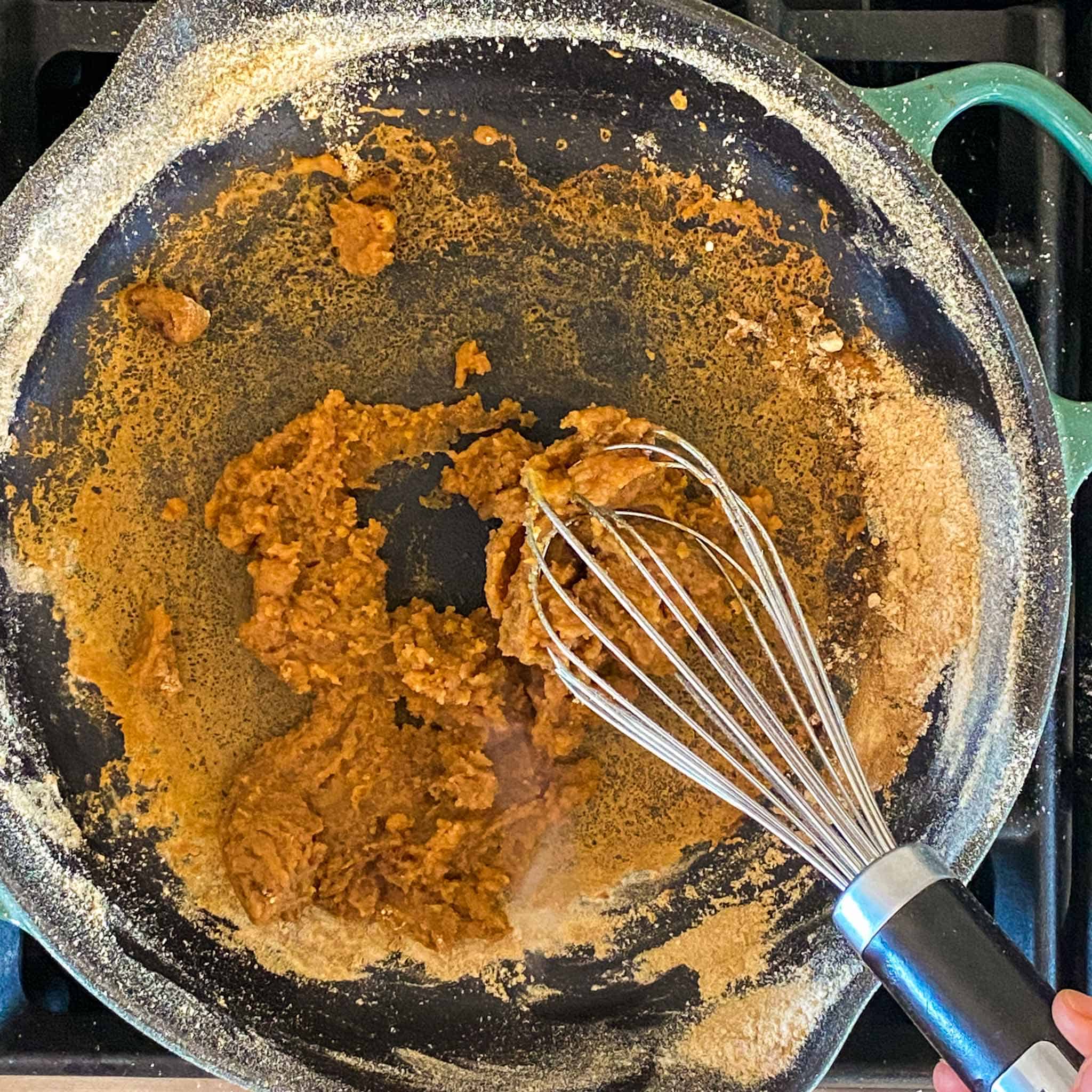 Drippings and flour forming a paste in a blue le crueset cast iron.
