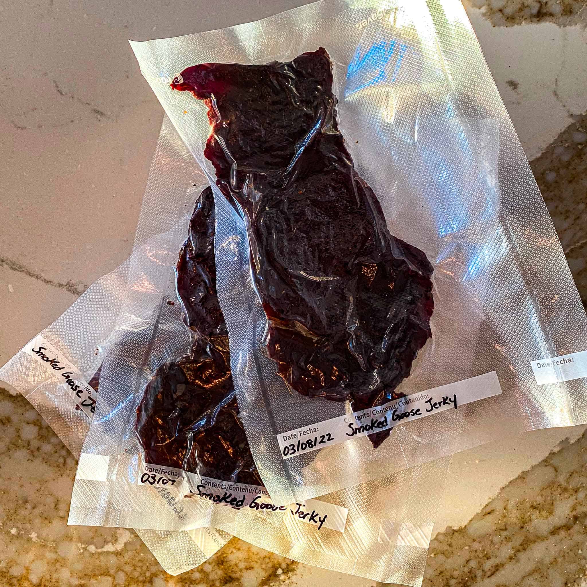 Goose jerky vacuum sealed in airtight bags and labelled for storage.