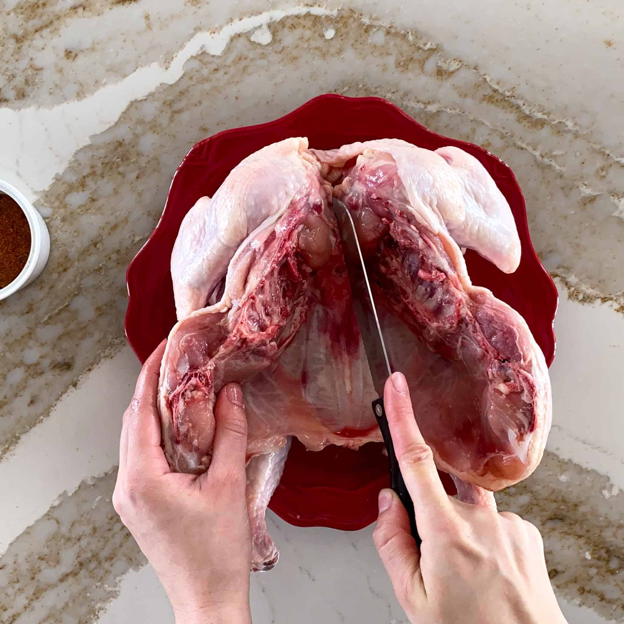 Cutting the breast bone of a spatchcock chicken open to help flatten it before smoking.