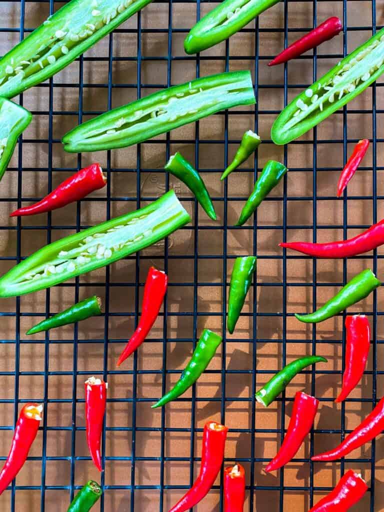 Peppers on a wire rack over a cookie sheet, ready to be dried in the oven.