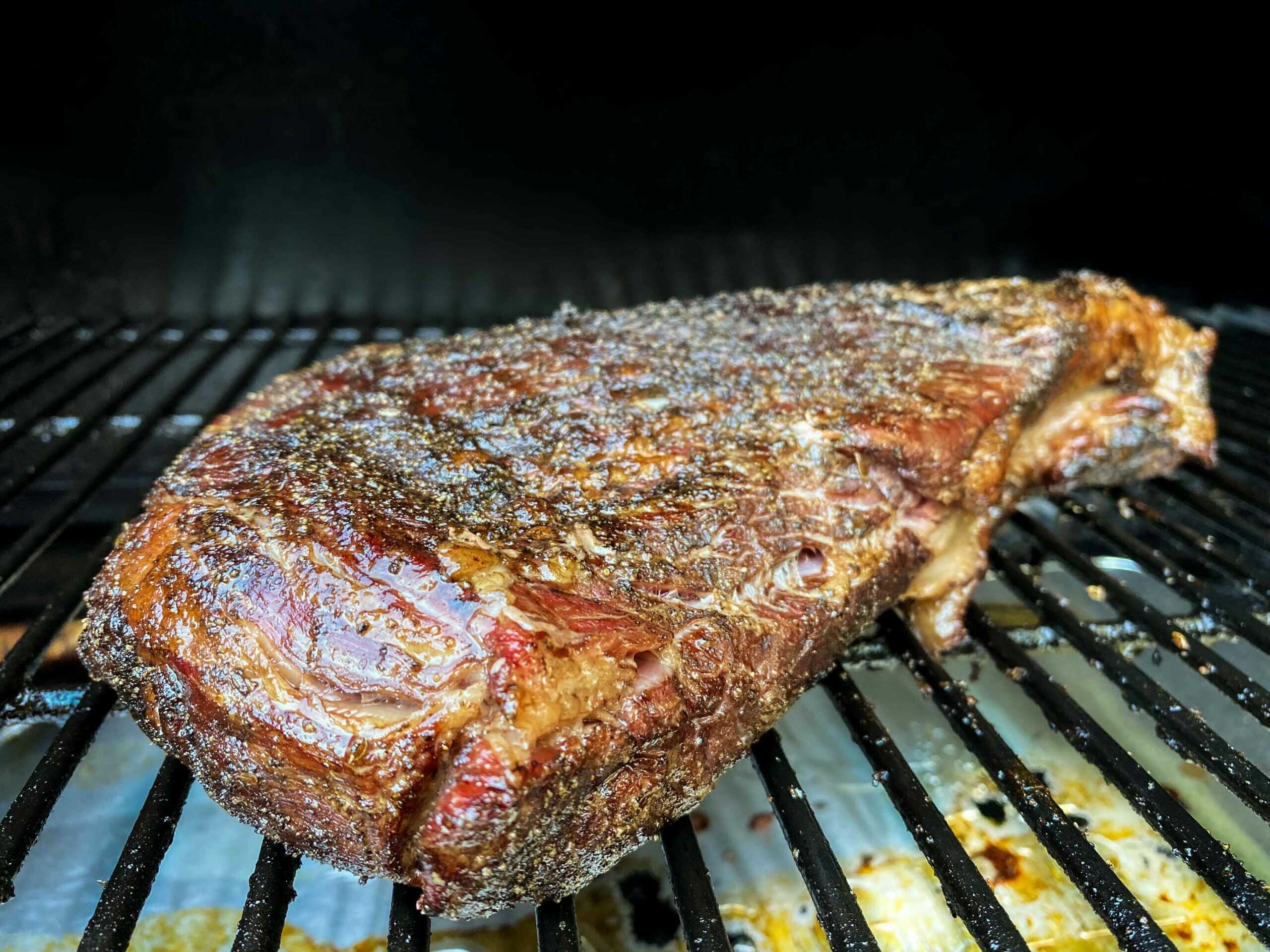 Close up view of a smoked tri tip roast on a pellet grill.