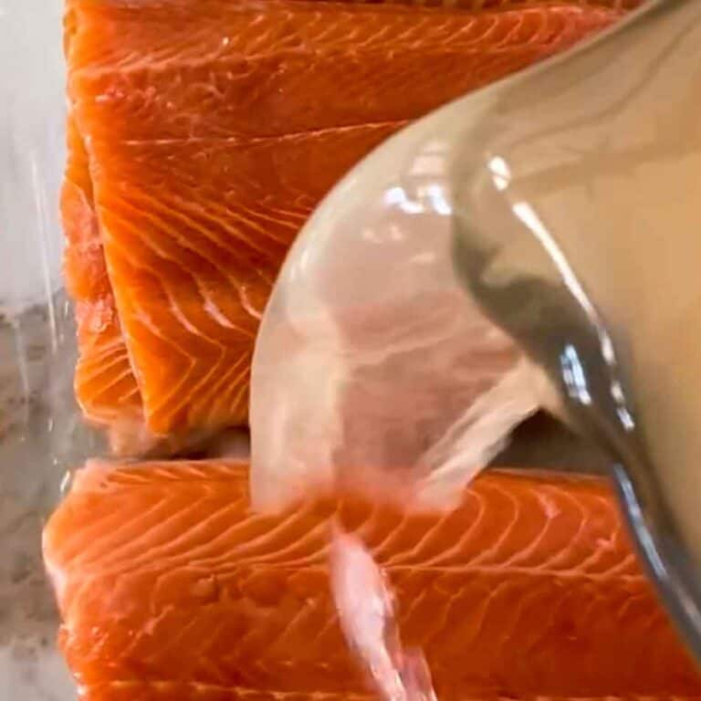 Simple brine being poured over four trout fillets.