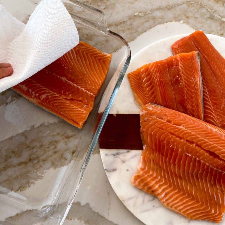 Blotting the brine trout fillets with paper towel before smoking.