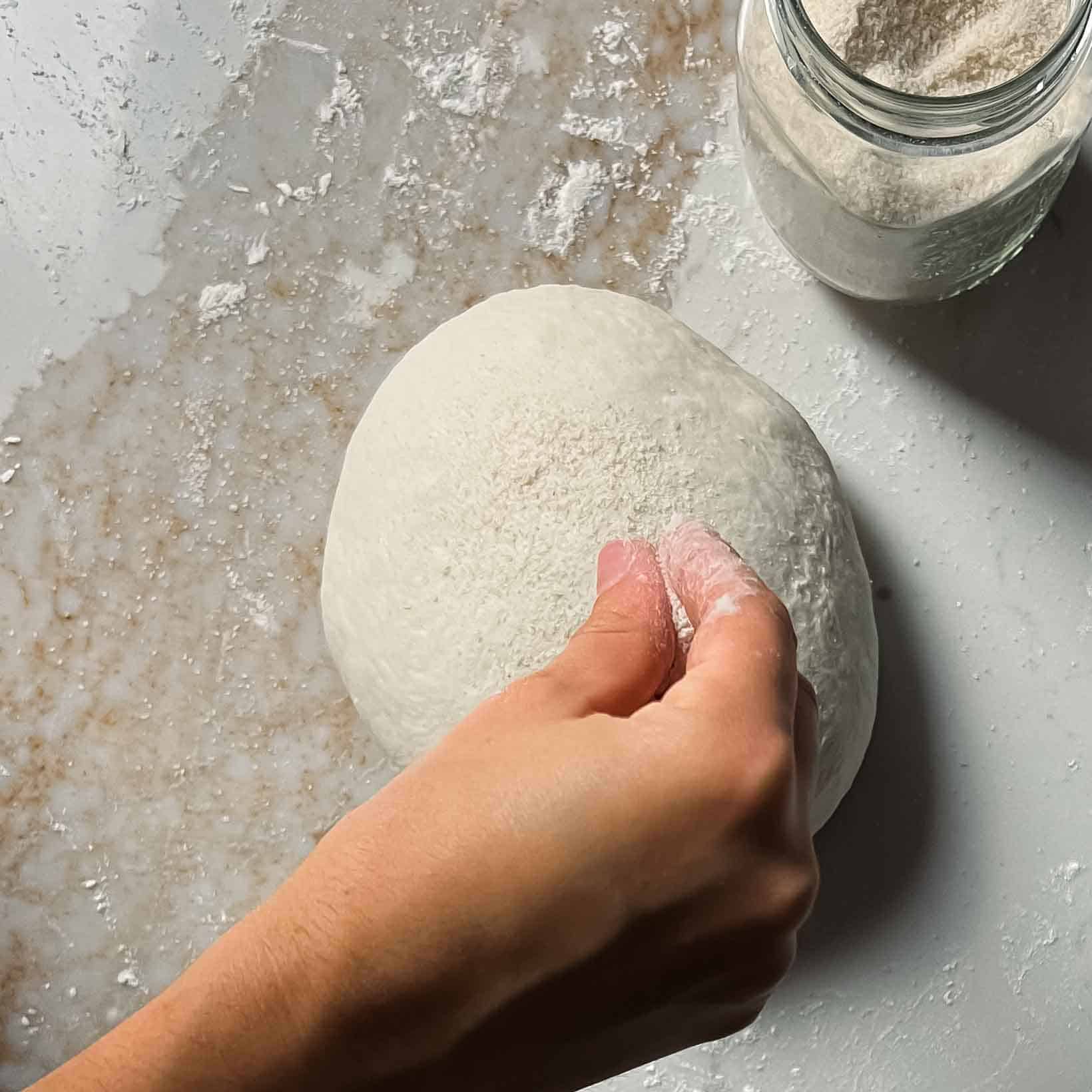 Sprinkling rice flour on bread machine sourdough.
