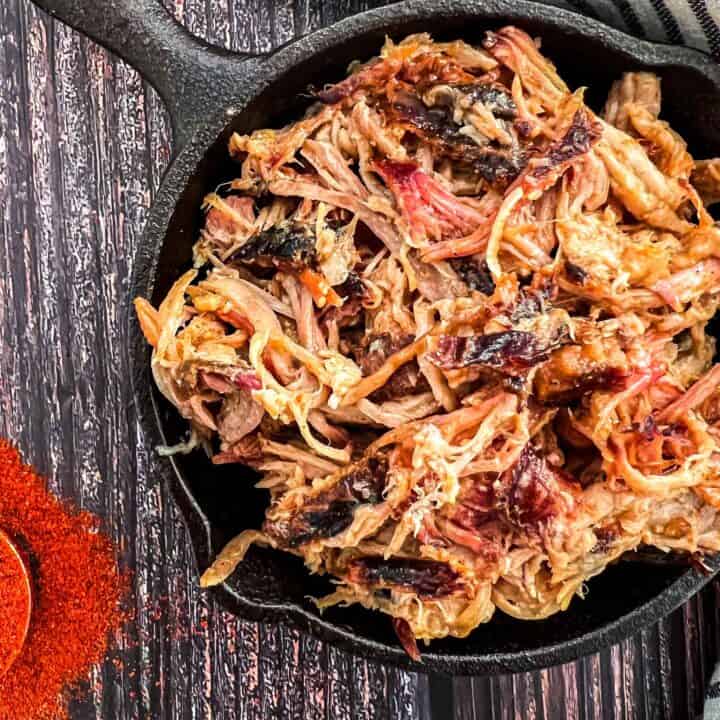 Treager pulled pork in small cast iron frying pans showing a rich brown colour.
