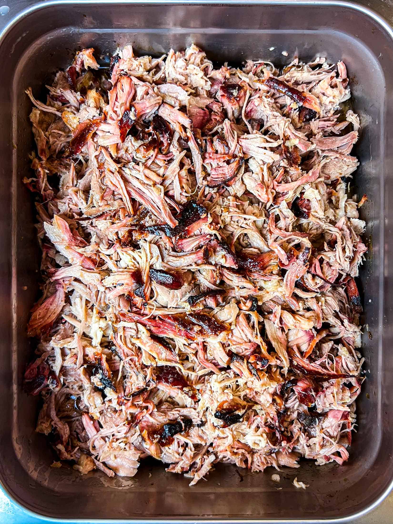 Shredded smoked pork butt in a chafing pan.
