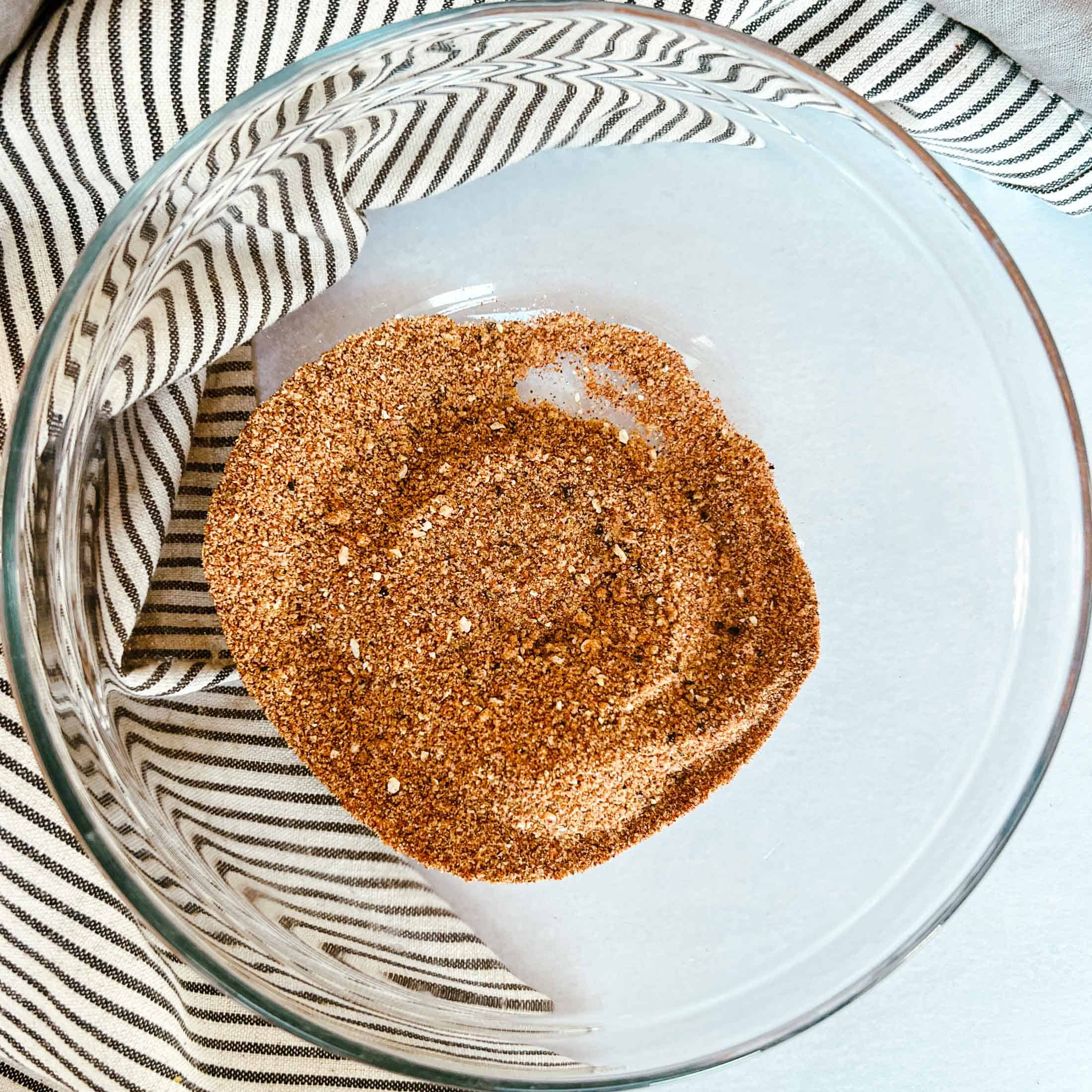Brown sugar and spices completely mixed in a glass bowl for pork rub.