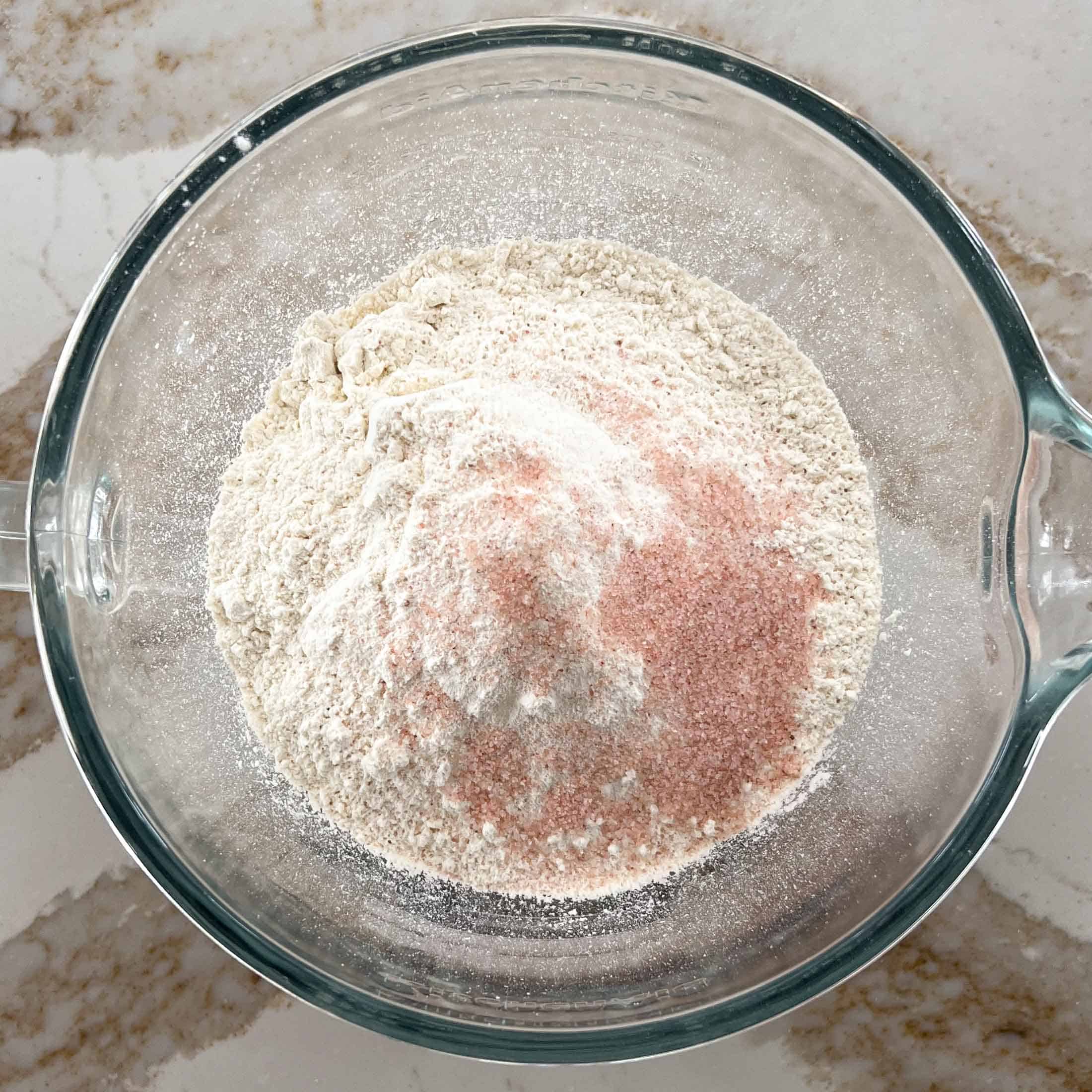 Dry ingredients in a glass bowl for sourdough sandwich loaf.
