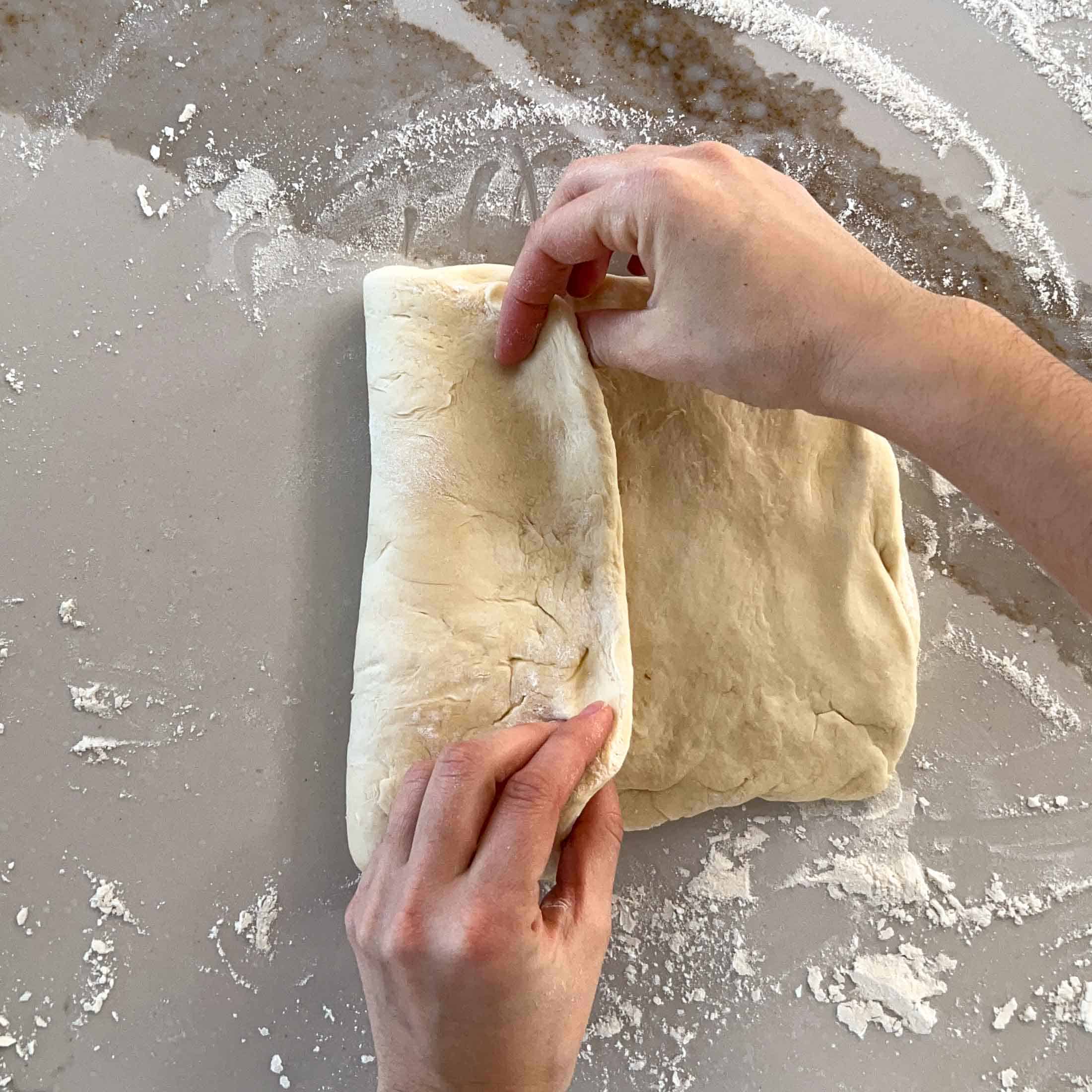 Folding sourdough into thirds to shape the dough into a sandwich loaf.