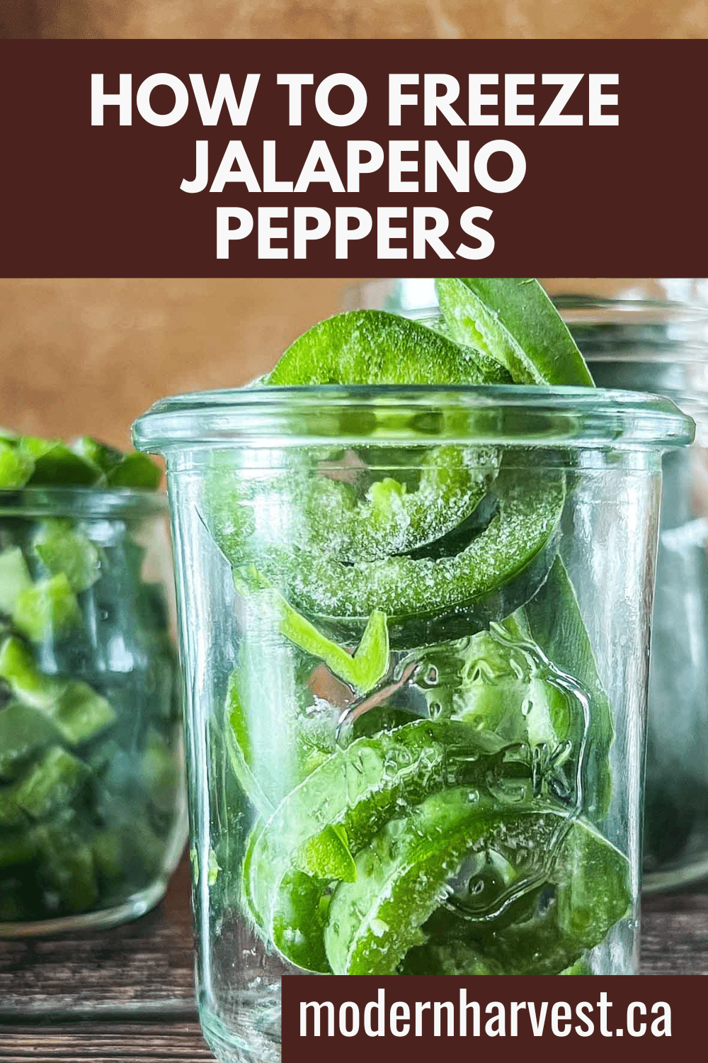 Frozen jalapenos in a glass jars with more frozen pieces scattered on a wooden surface.