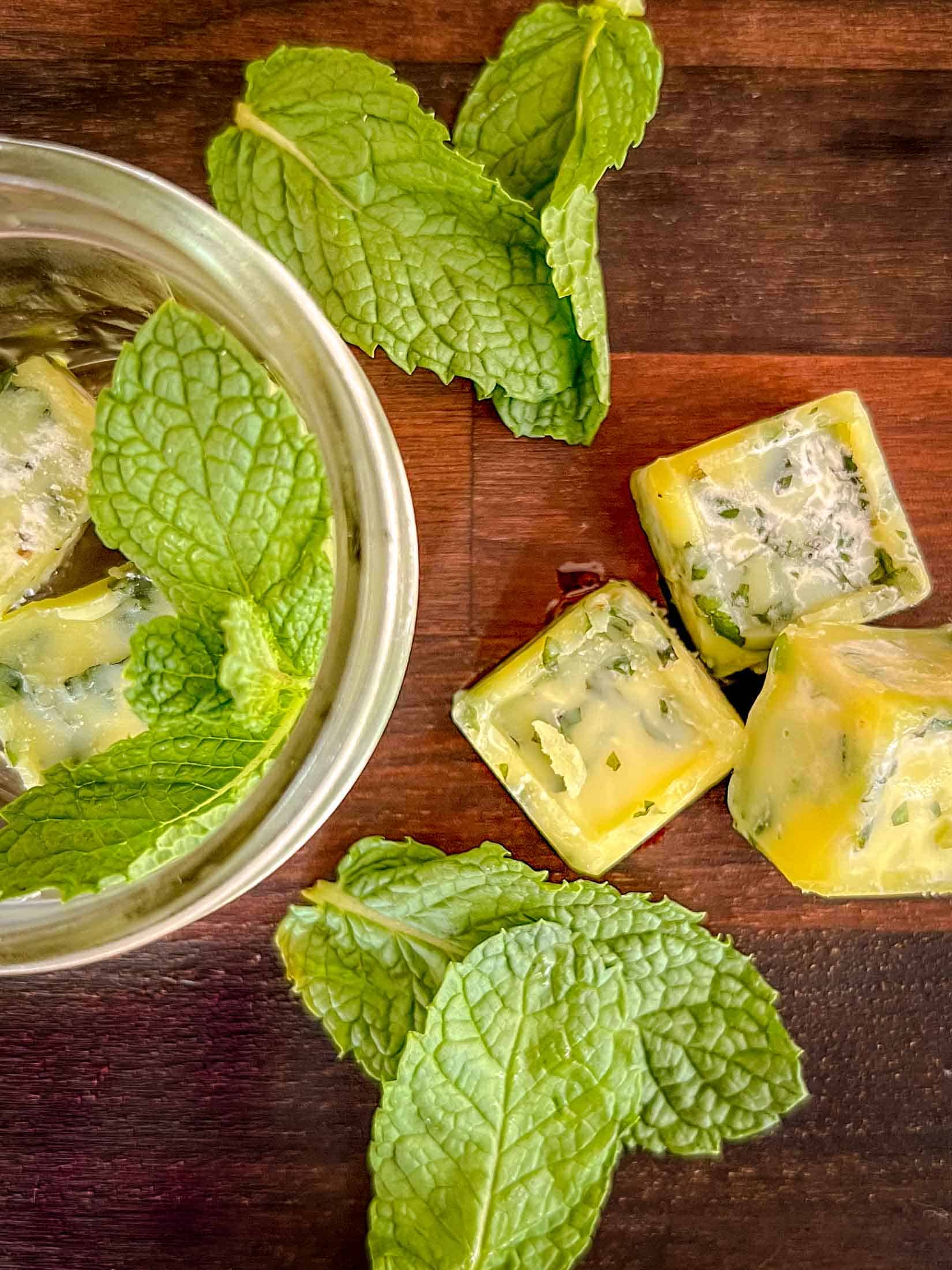 Mint leaves chopped and frozen in olive oil in cube form with fresh mint leaves as garnish.