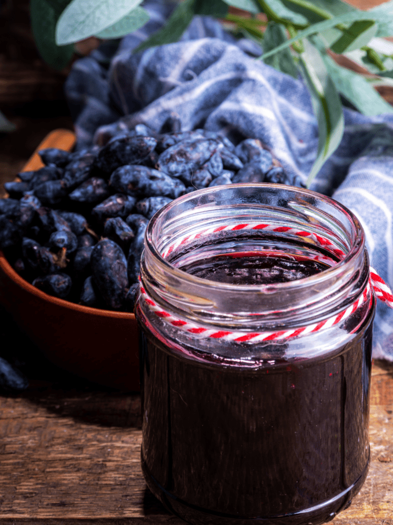 haskap jam in a jar with fresh haskap berries in the backdrop. 
