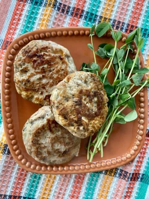 Easy breakfast sausages on an orange plate.