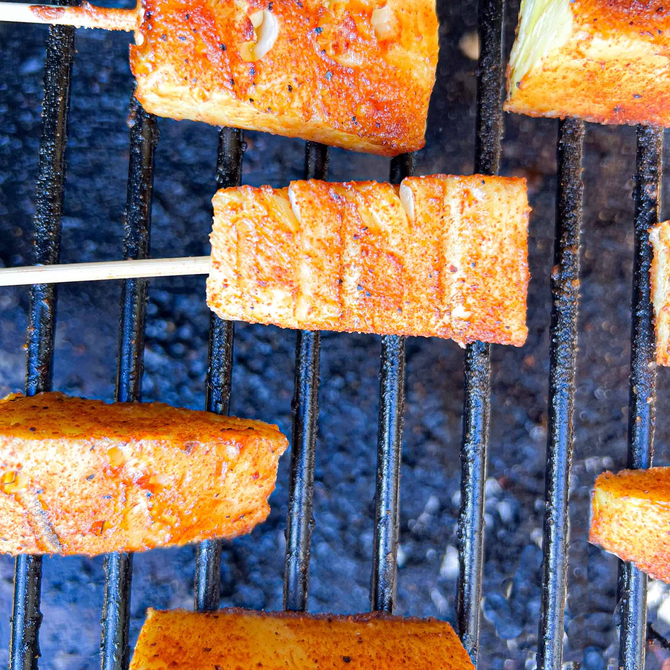 Pineapple on grill grates being smoked.
