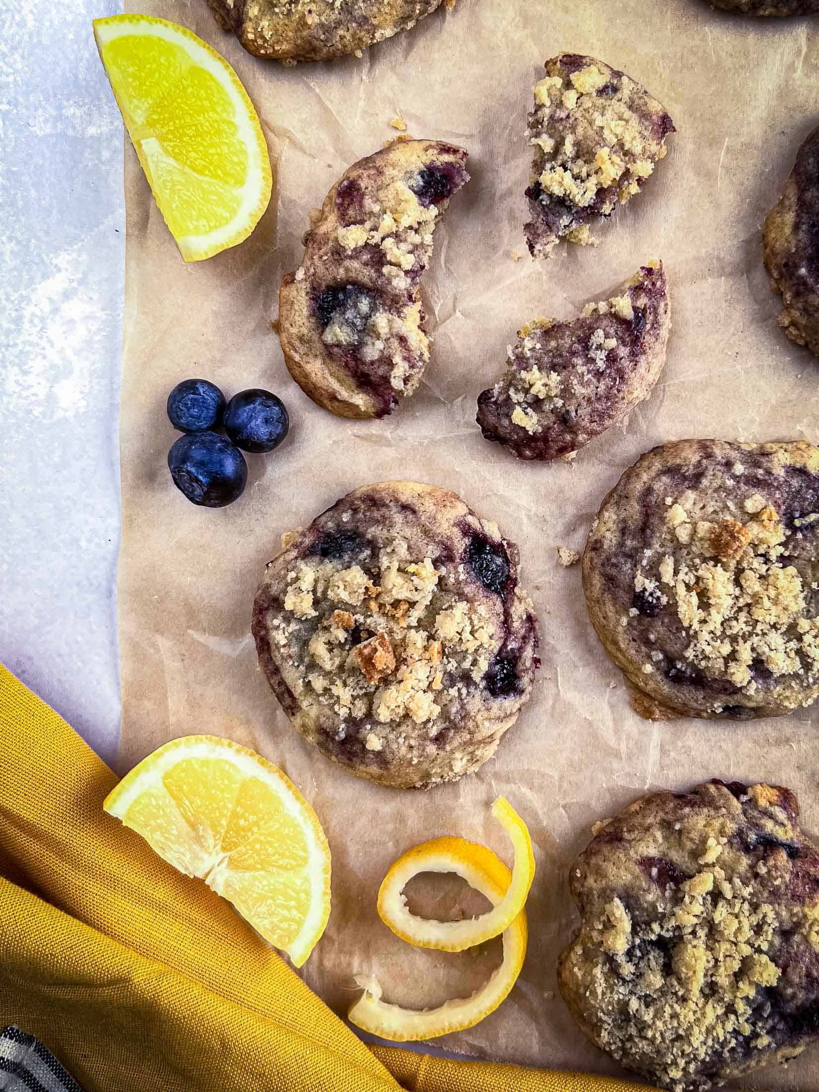 Lemon blueberry cookies on a piece of brown parchment with blueberry