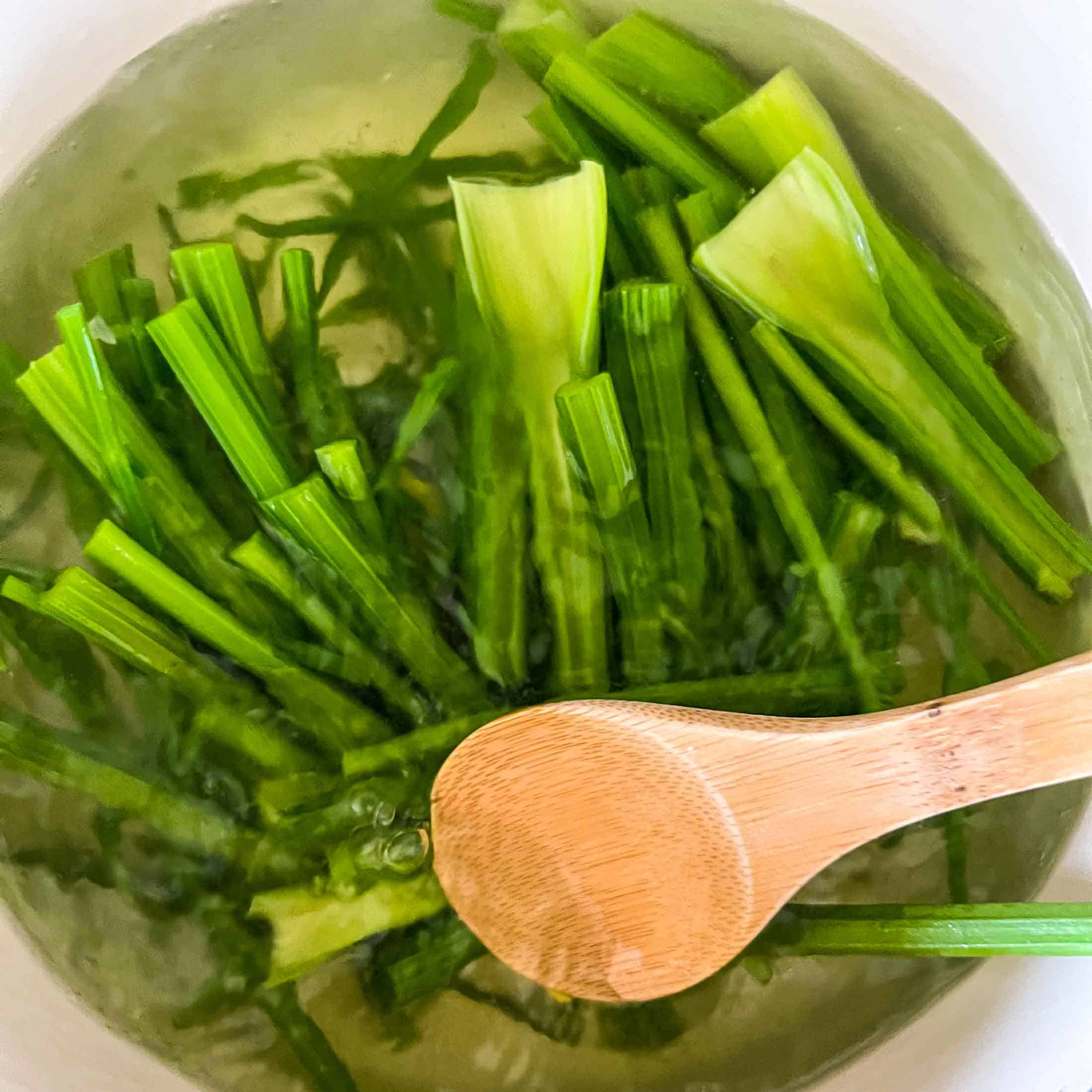 Celery stalks in a large pot filled with boiling water.