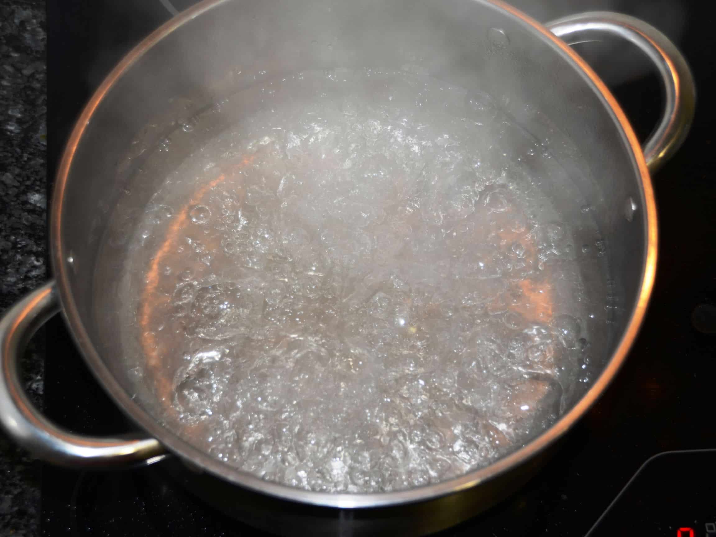 Boiling water in a stainless steel pot.