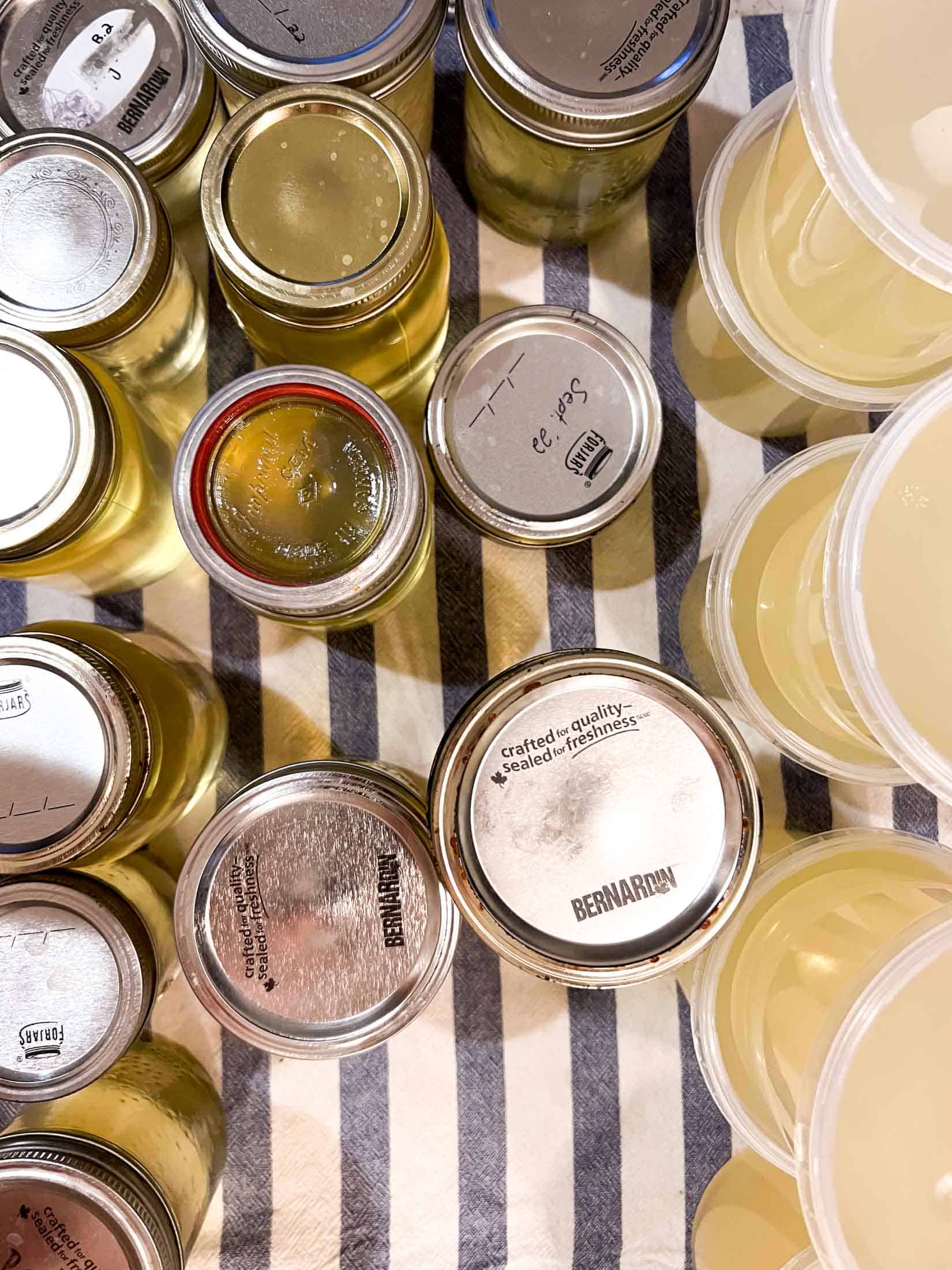An overhead view of rendered pork fat in jars and glass containers.