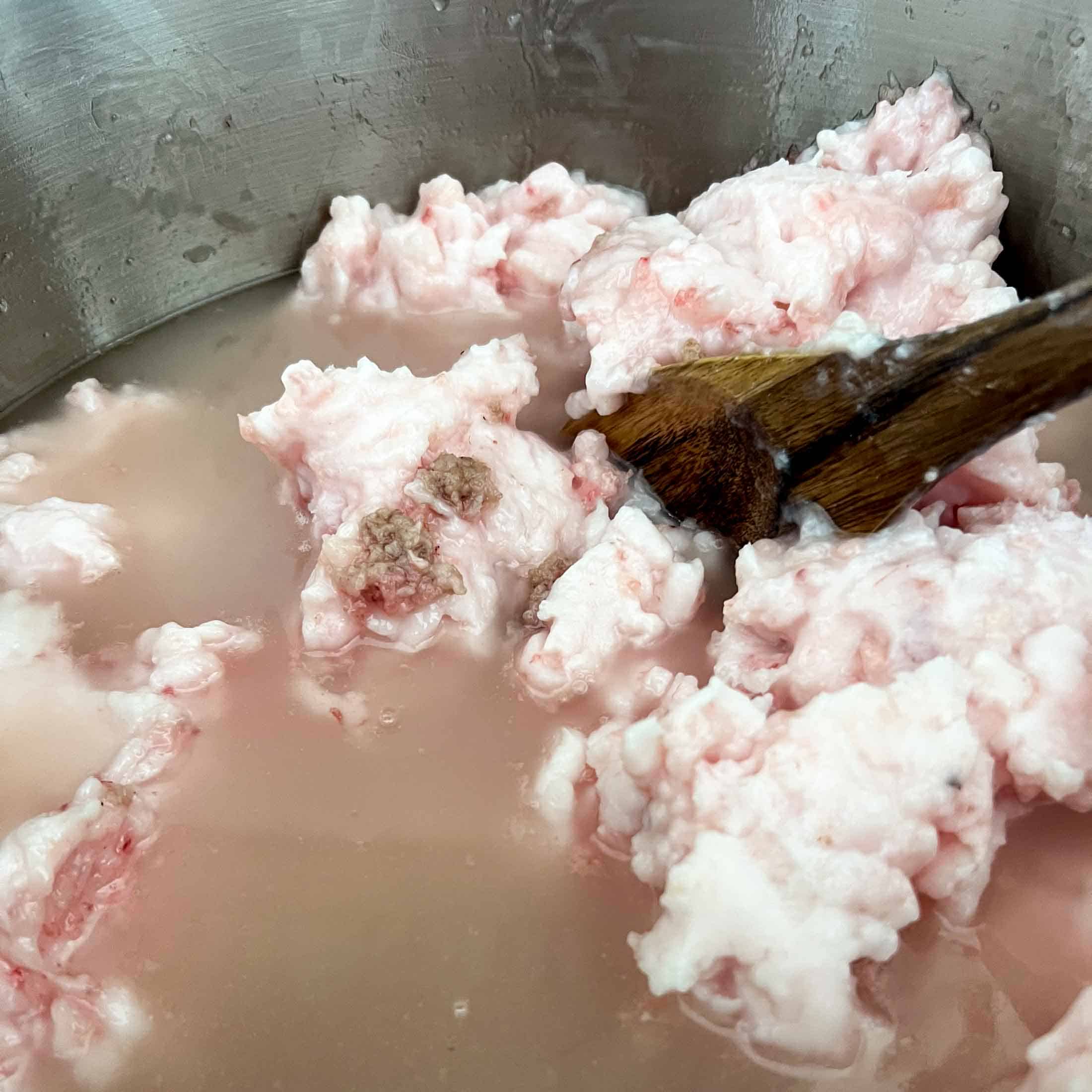 A large amount of lard in a big stock pot with both solid fat and melted fat being incorporated.