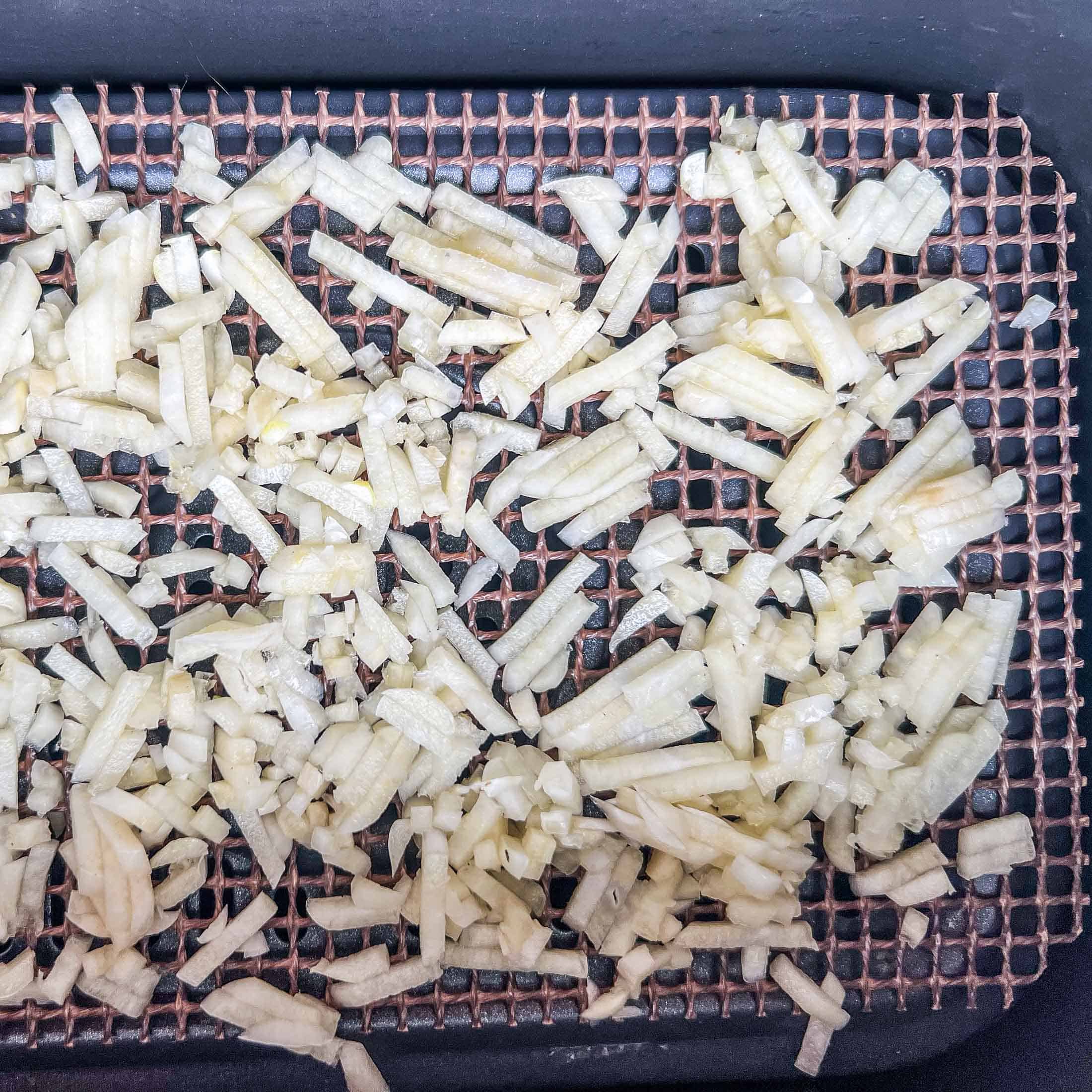 Minced garlic in an air fryer basket.