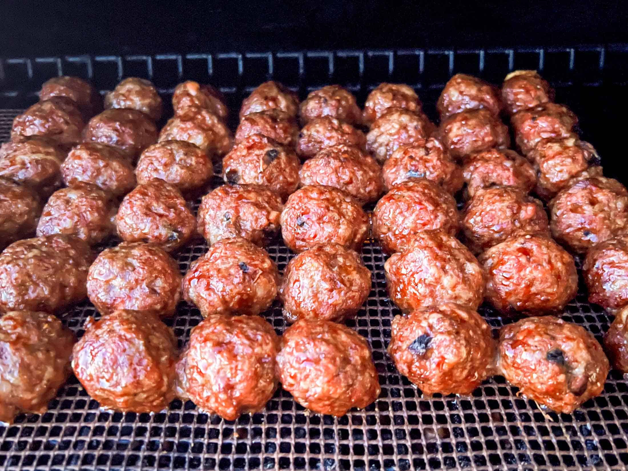 Venison meatballs on a grill mat on a Traeger pellet grill.