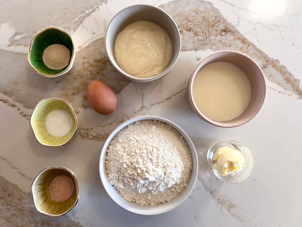 Key ingredients for sourdough english muffins recipe including eggs, flour, milk, butter, sourdough discard.