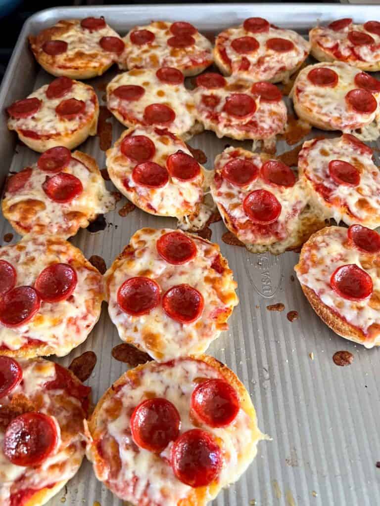 English muffins made into mini pizzas on a sheet pan.
